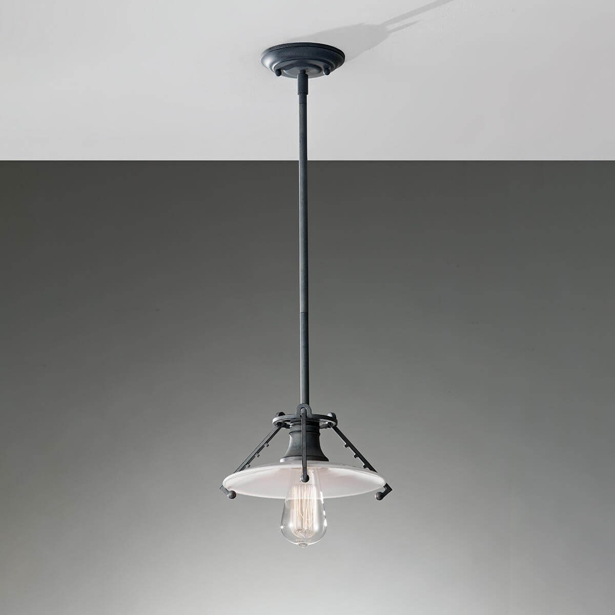 Luminaire suspendu au plafond dans une pièce grise, mise en ambiance sobre.