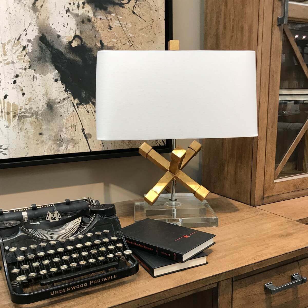 Scène de bureau en bois avec machine à écrire ancienne, livres et lampe dorée