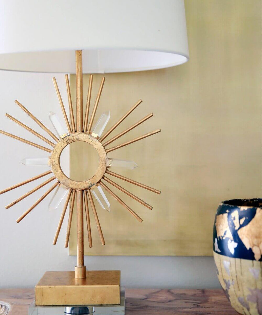 Détail du motif soleil doré et des cristaux transparents sur fond jaune.