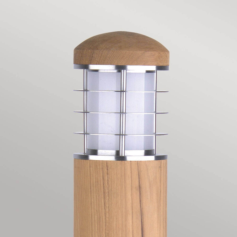 Gros plan sur la tête en bois et la grille métallique du diffuseur.