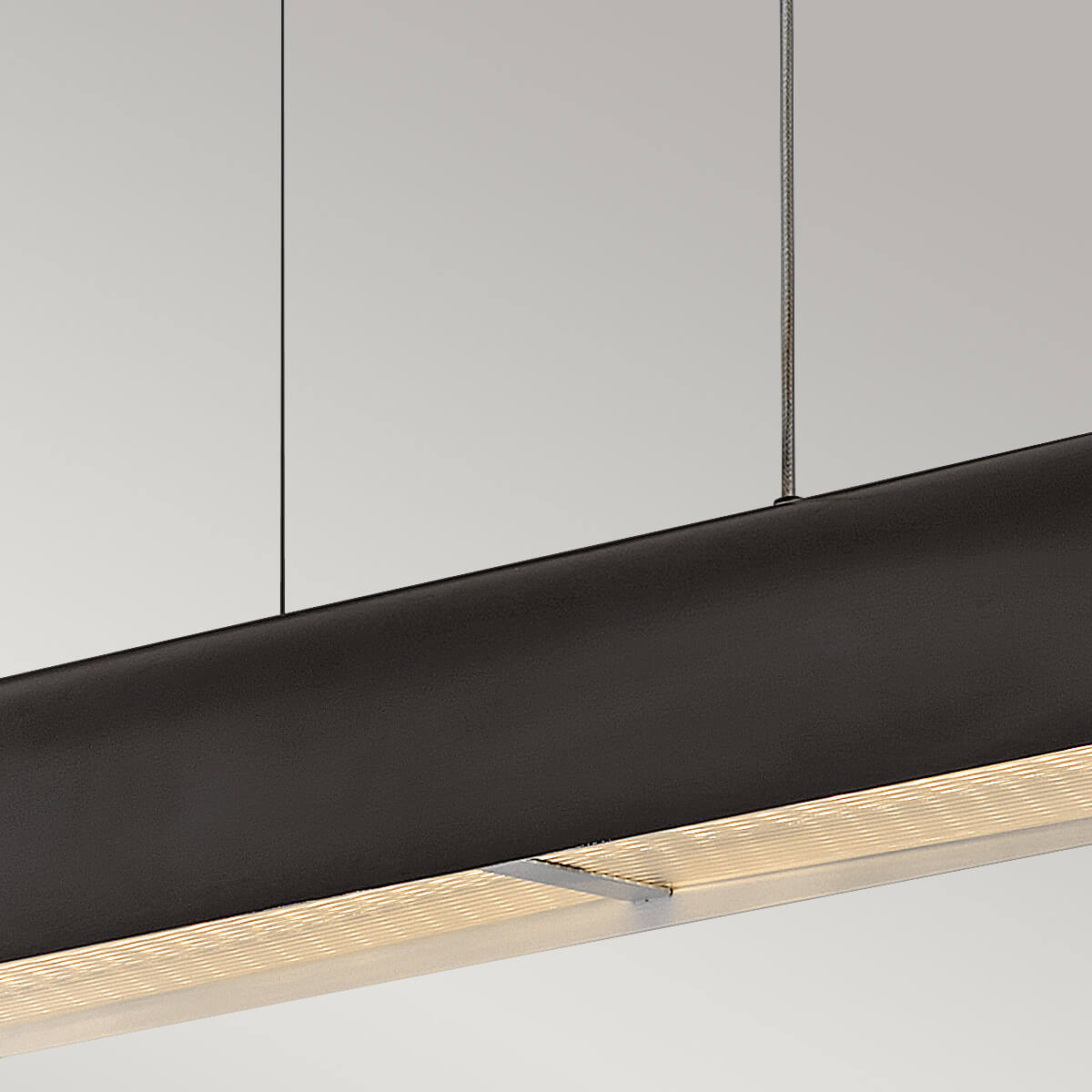 Mise en ambiance d'un intérieur moderne avec la suspension linéaire allumée au-dessus d'une table