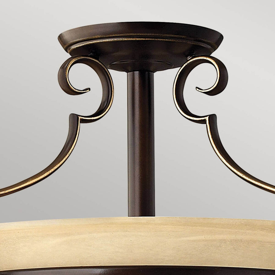 Détail du raccord au plafond et des volutes en bronze doré