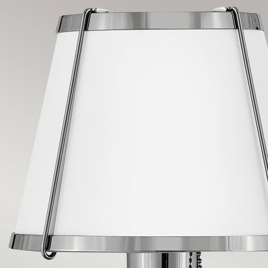 Détail rapproché de l'abat-jour en verre blanc et de son cerclage