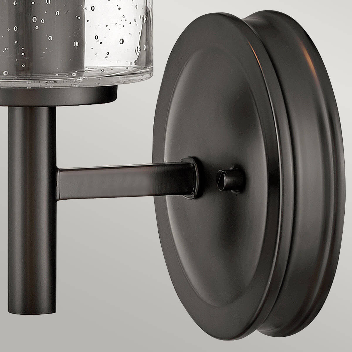 Vue rapprochée de la platine ronde noire et du bras de fixation au mur