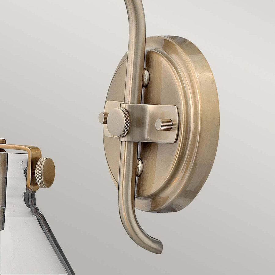 Détail de la platine ronde fixée au mur avec molette moletée et bras recourbé