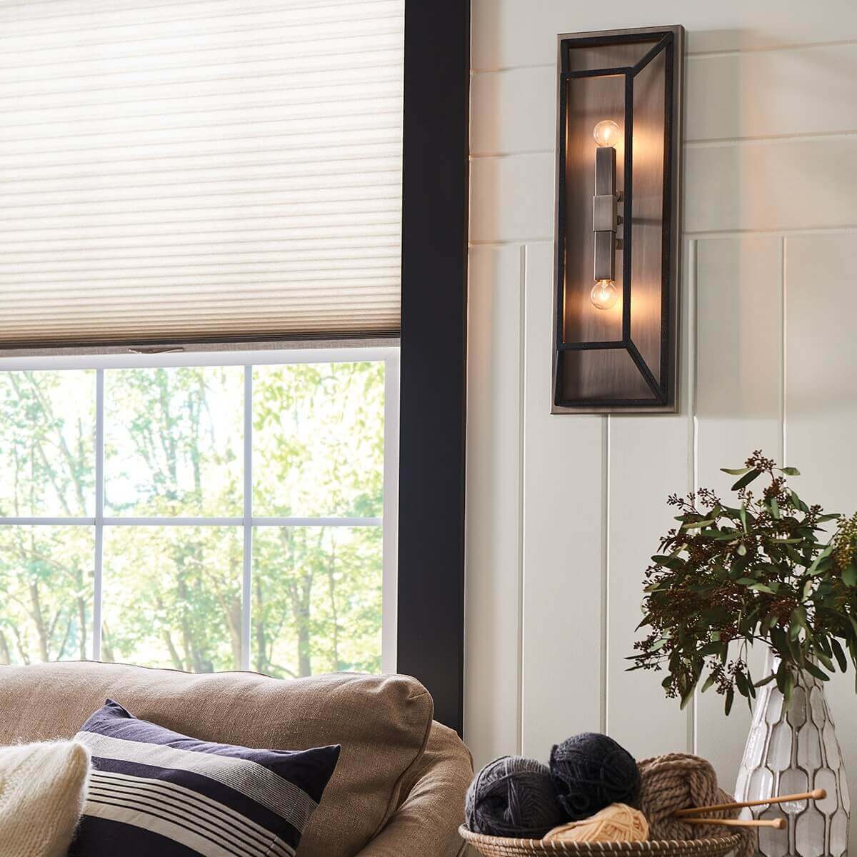 Mise en ambiance salon lumineux, applique allumée fixée sur mur blanc à lattes