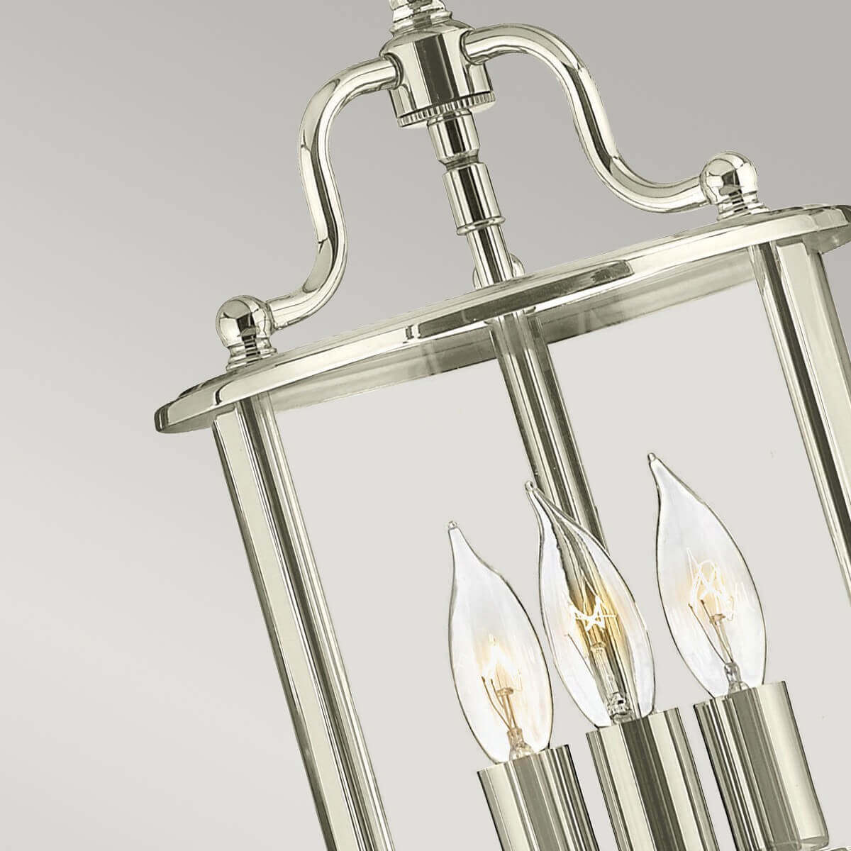 Gros plan du sommet et des trois ampoules bougies, finition argentée et verre transparent.