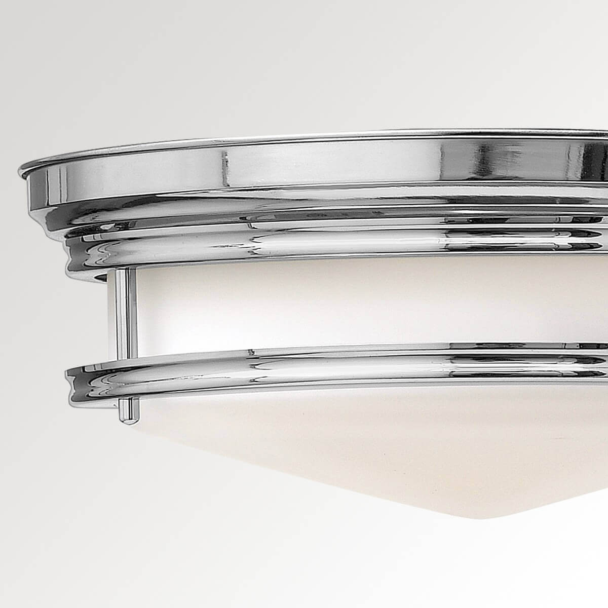 Gros plan sur la finition chromée polie et les attaches du luminaire de plafond