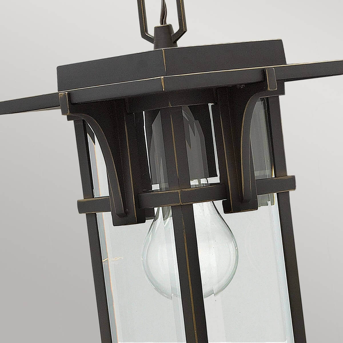 Gros plan sur le haut du luminaire, arche décorative et ampoule visible.