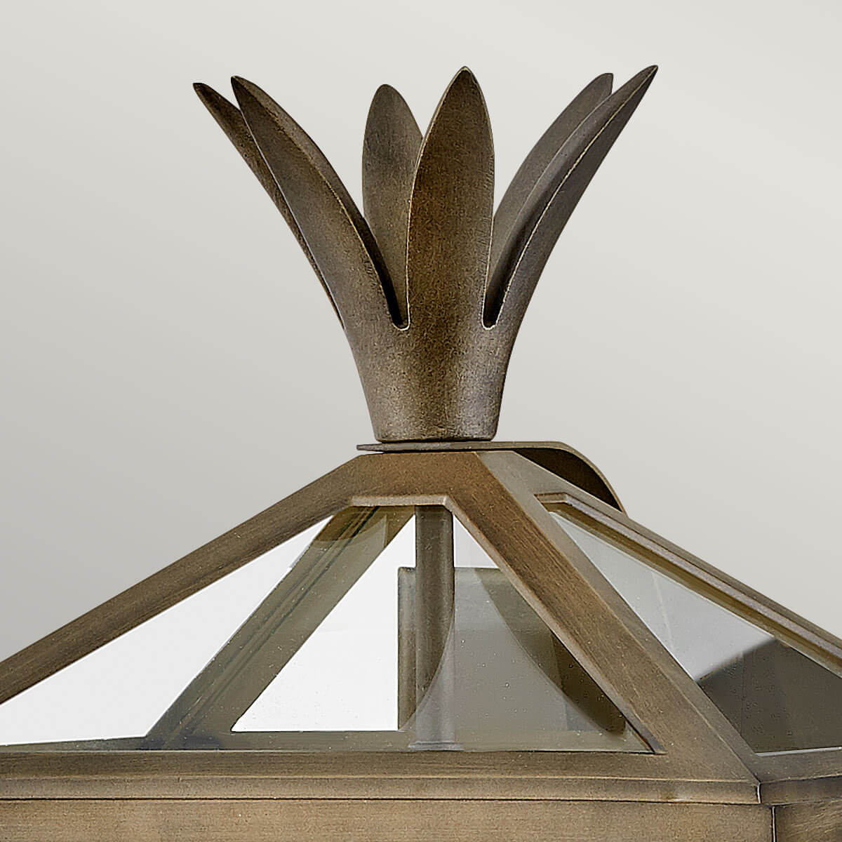 Gros plan sur la couronne de feuilles métalliques coiffant le sommet du luminaire