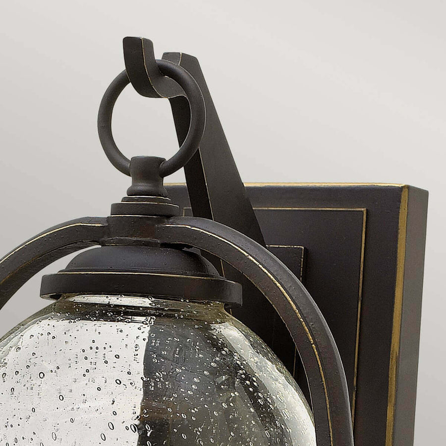 Détail du sommet avec anneau décoratif, support métallique bronze et calotte en verre granité.