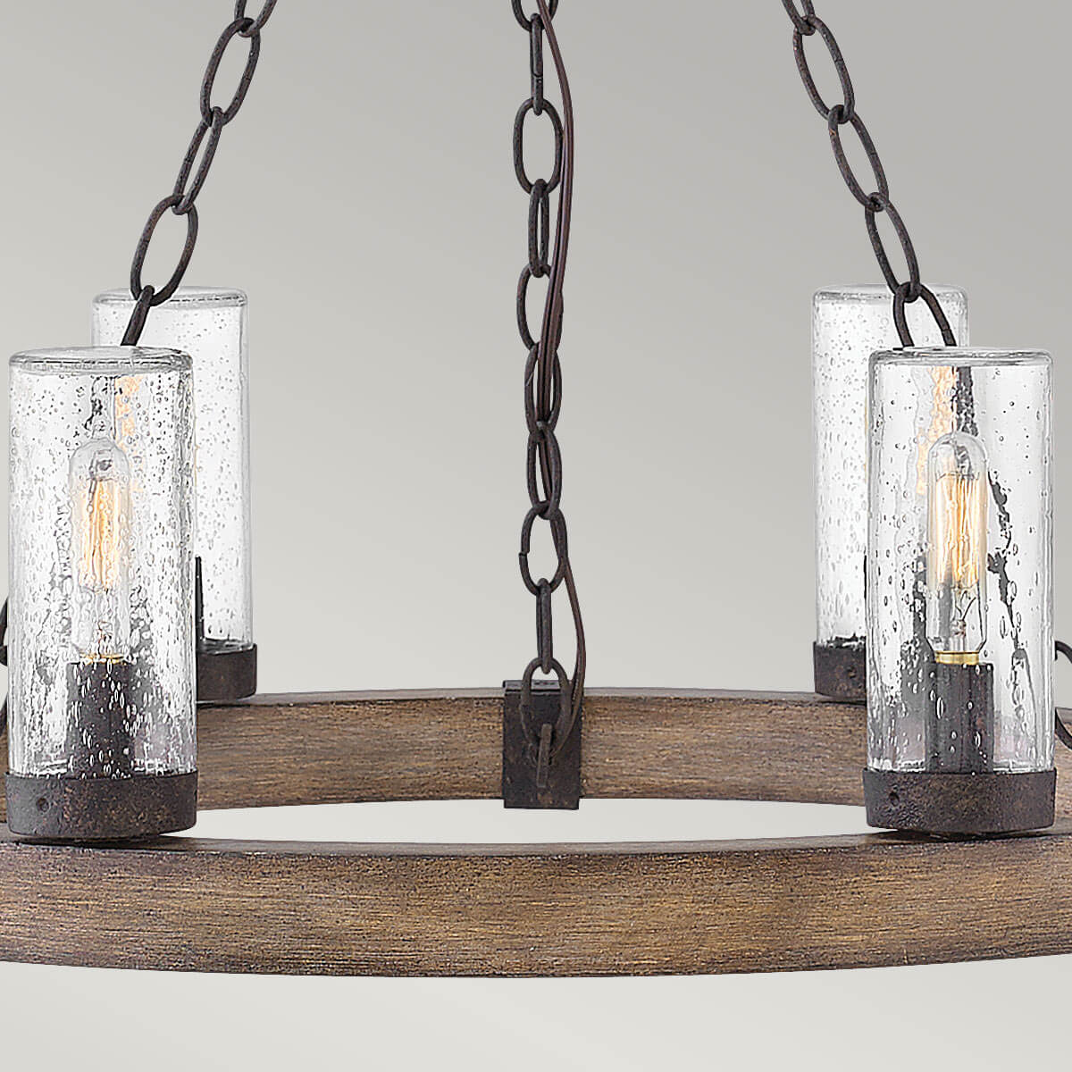 Vue rapprochée de l'anneau en bois et des lanternes cylindriques en verre.
