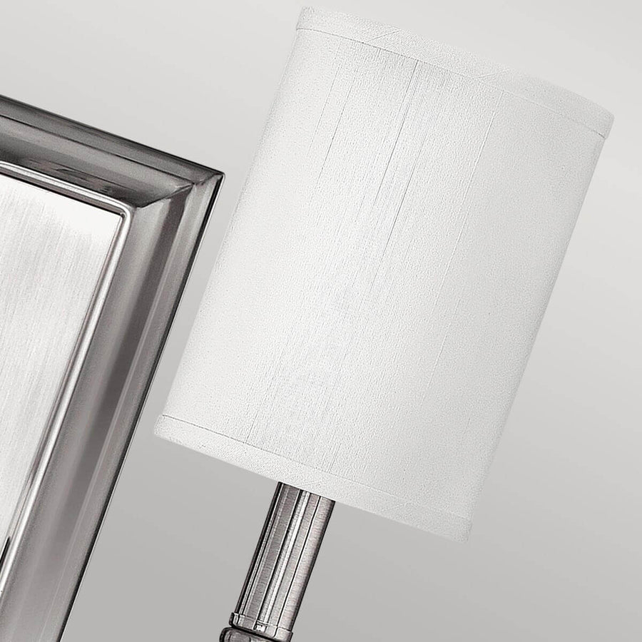Détail de l'abat-jour textile blanc et de l'encadrement biseauté de la platine