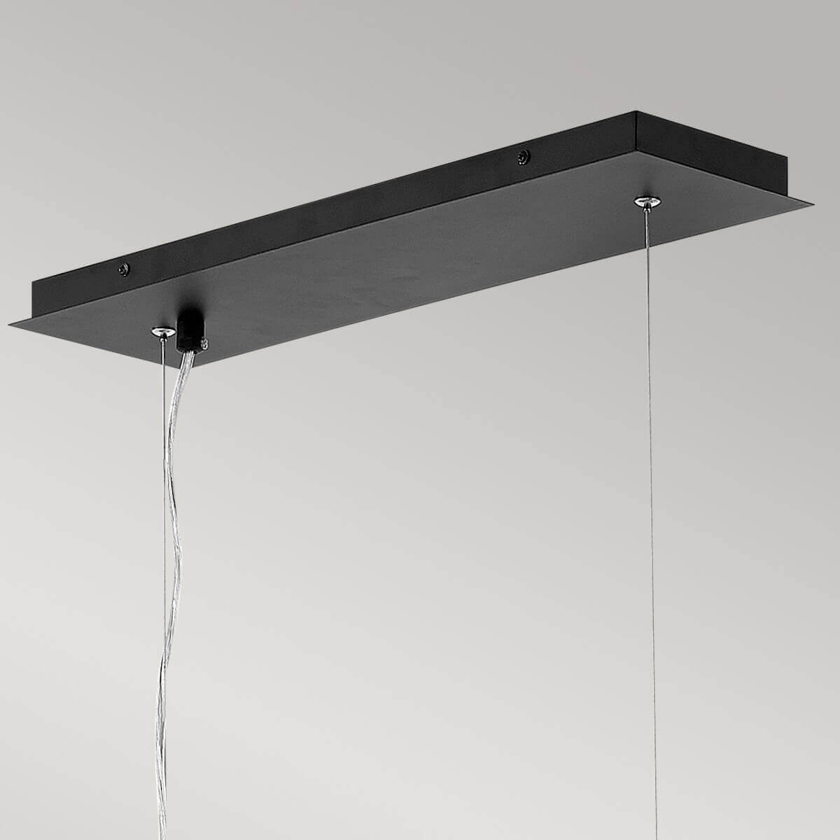 Détail de la platine rectangulaire noire fixée au plafond avec ses câbles
