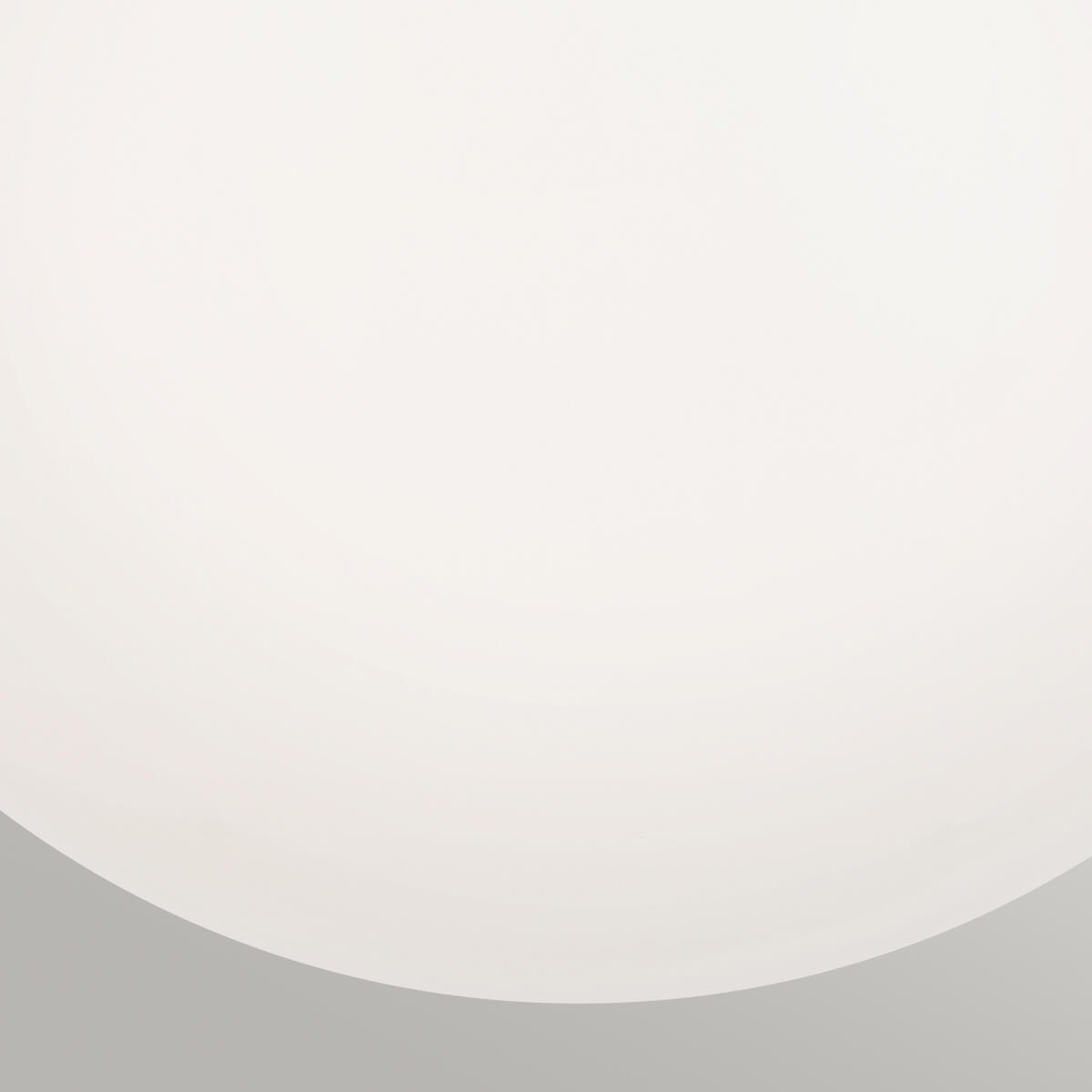 Gros plan sur la surface lisse et laiteuse du globe en verre opale dépoli.