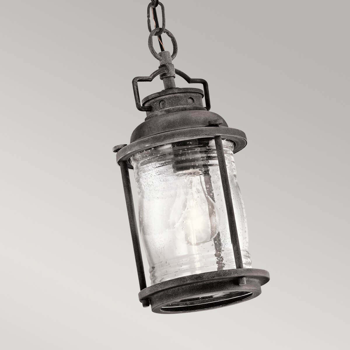 Gros plan sur la lanterne en verre strié avec ampoule allumée.