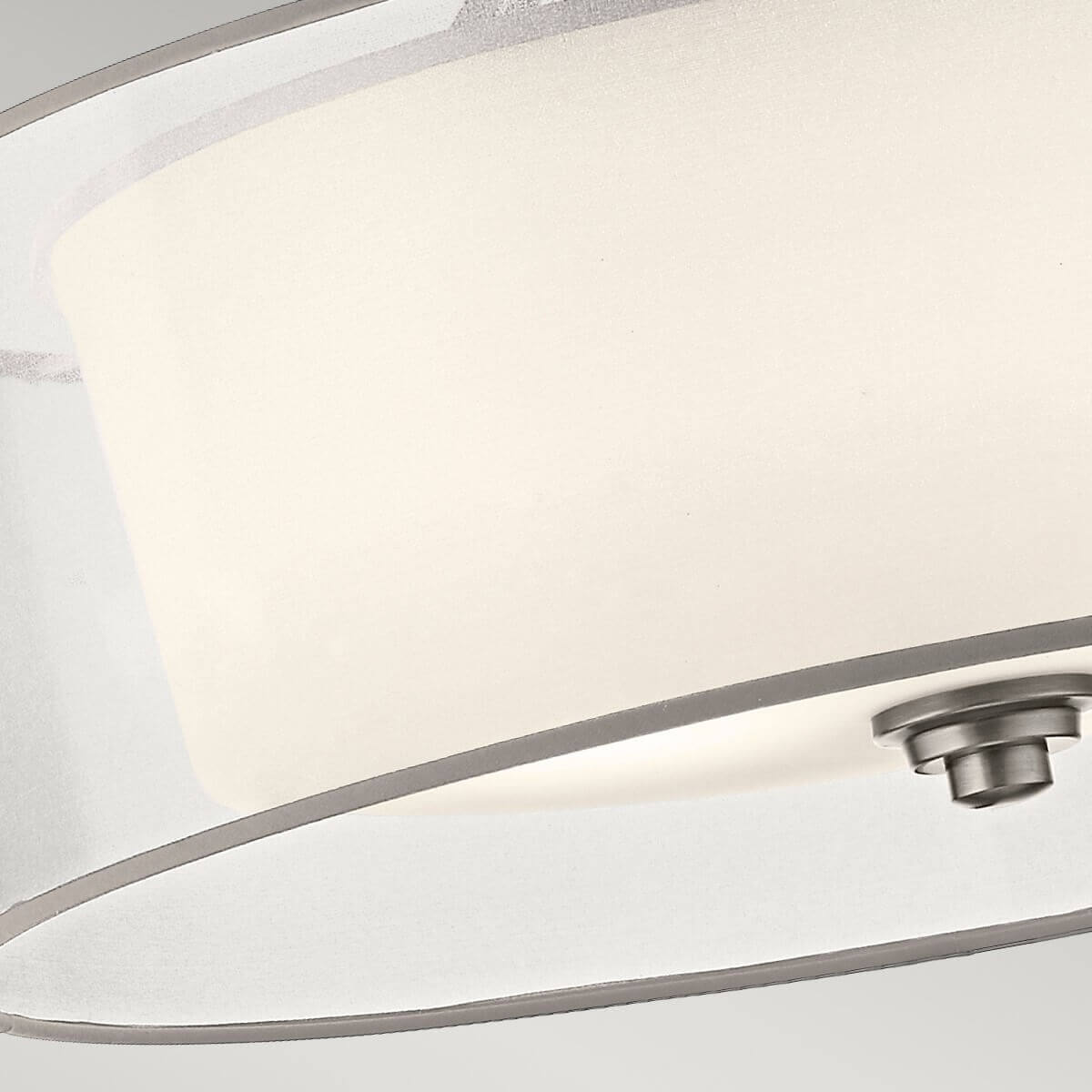 Gros plan sur le bord inférieur, le diffuseur blanc et la fixation centrale sous le luminaire.