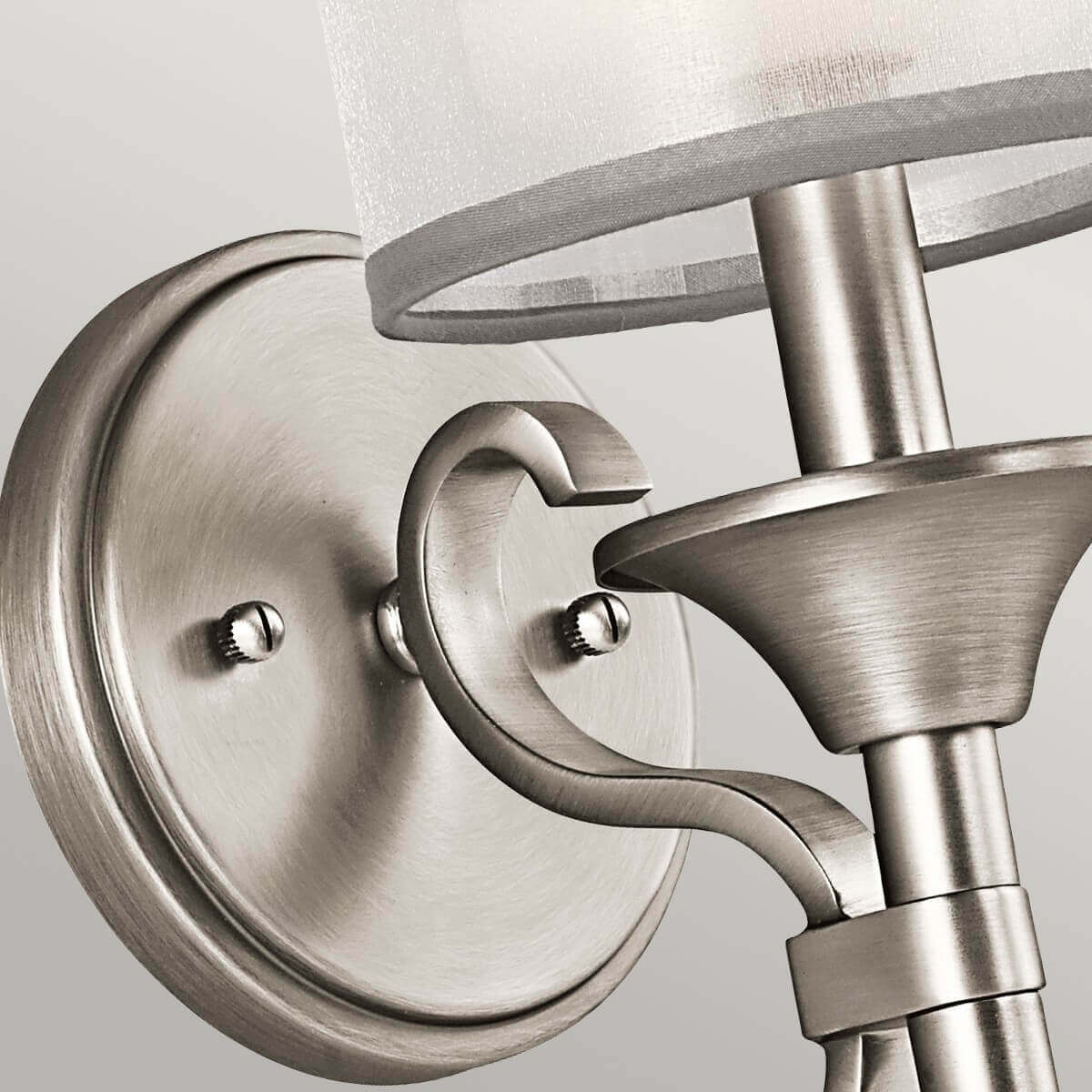 Détail de la platine ronde et de l'attache du bras incurvé en métal brossé