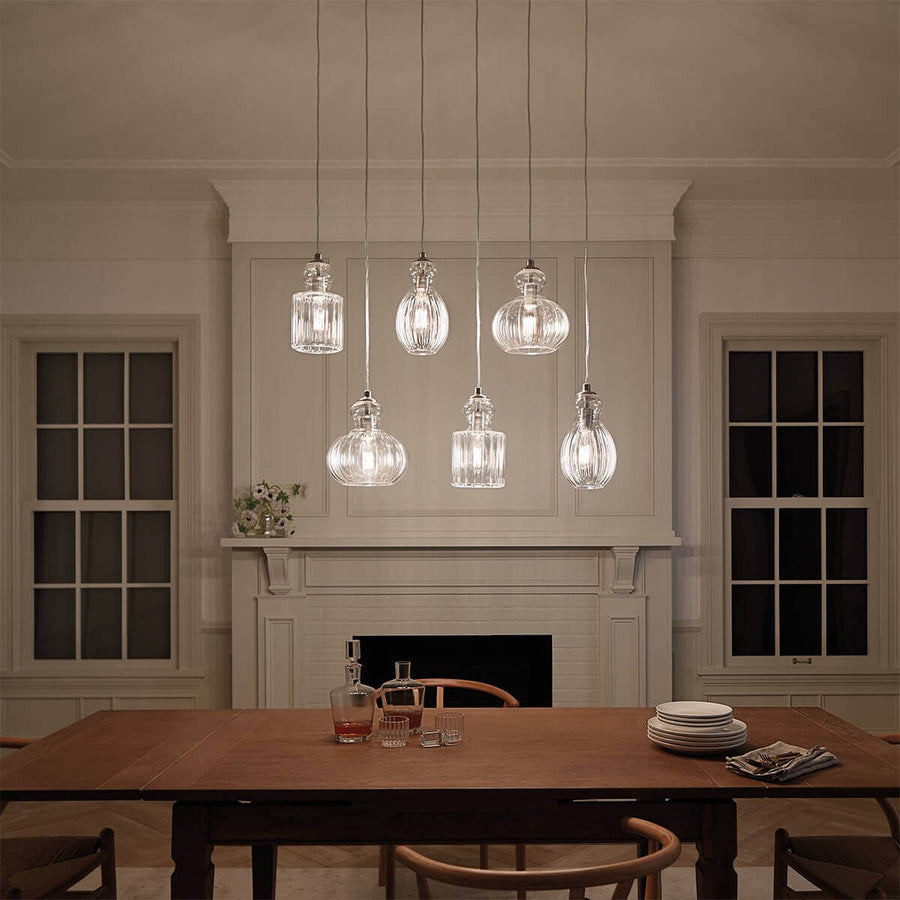 Mise en ambiance nocturne : suspensions allumées au-dessus de la table dressée.