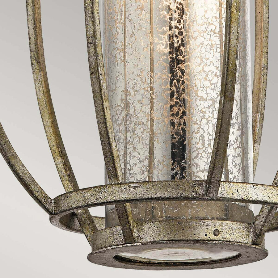 Détail du bas avec verre moucheté, cercle métallique et finition dorée usée.