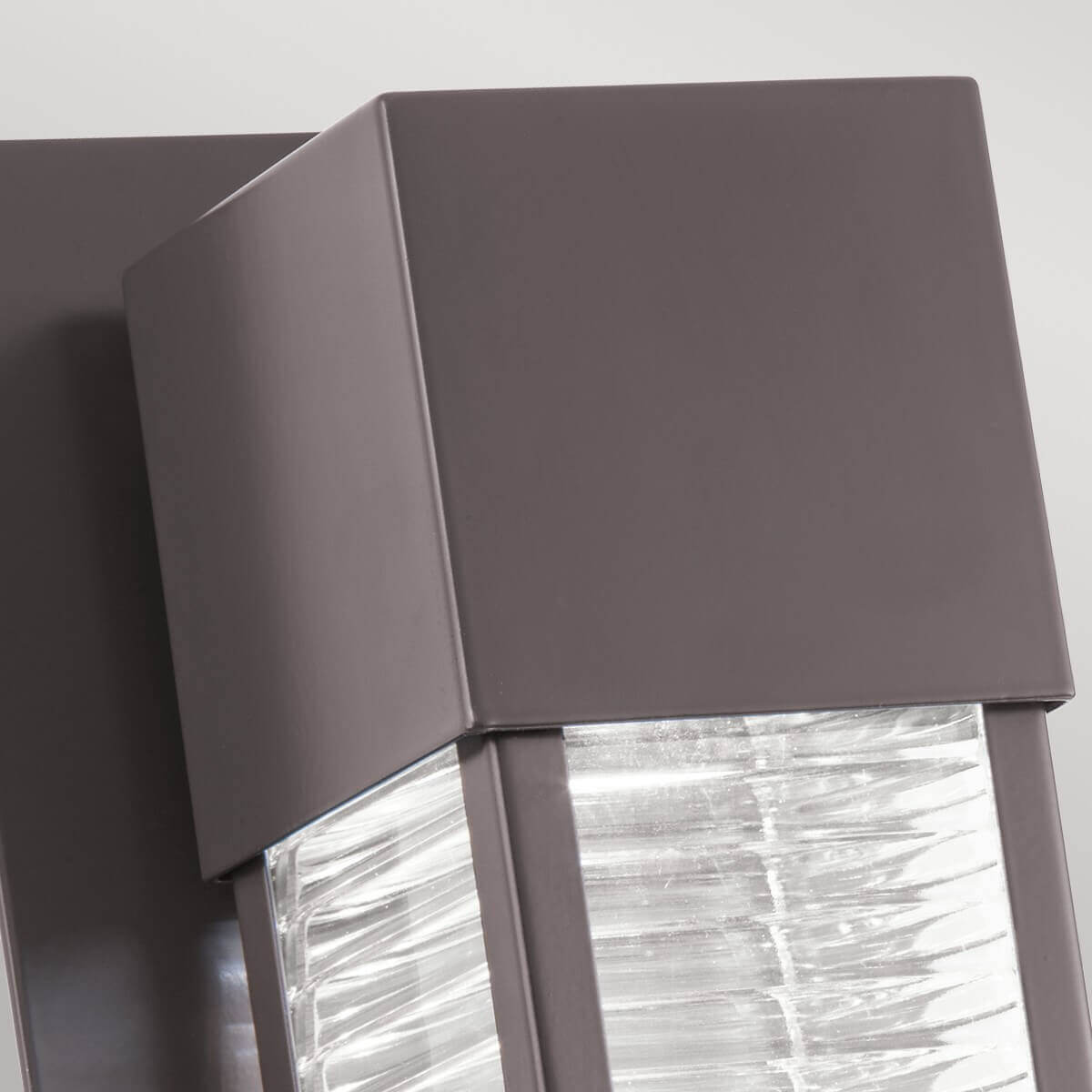 Détail du coin supérieur, capot métal bronze mat et arêtes nettes du cadre