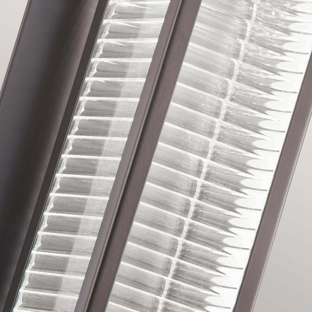 Gros plan du verre strié, fines nervures horizontales réfractant la lumière en éclats