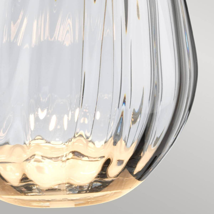 Gros plan du bas de la base en verre transparent aux reflets dorés