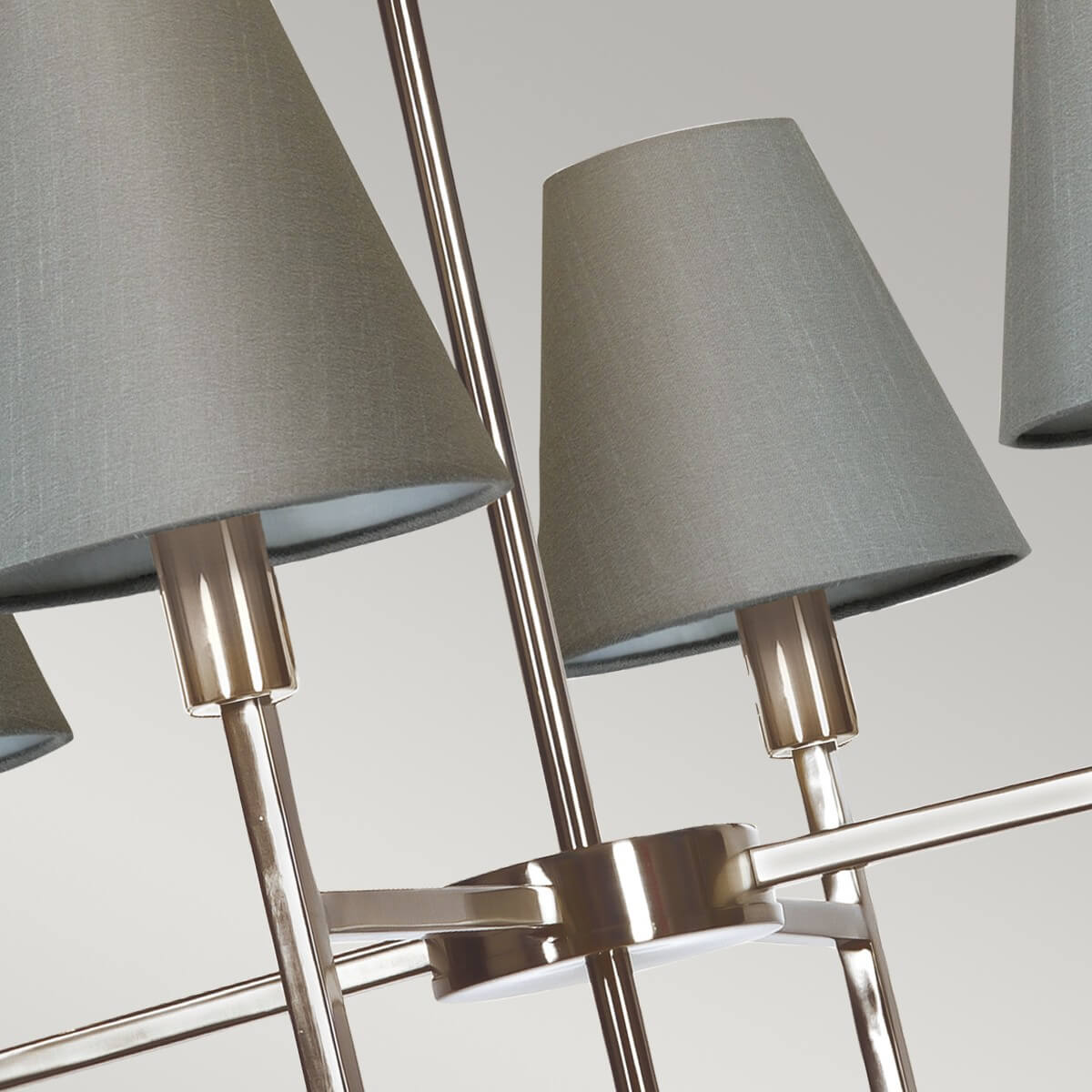 Détail du centre : bras croisés en métal nickelé et douilles cylindriques brillantes