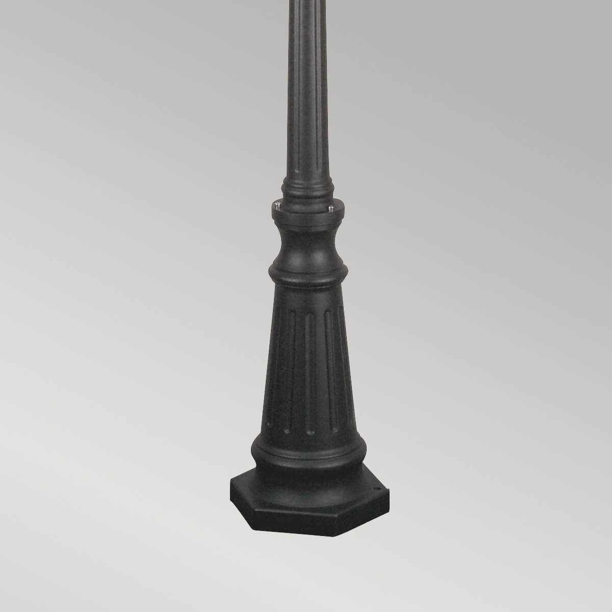 Détail de la base trapézoïdale cannelée posée sur un socle octogonal noir