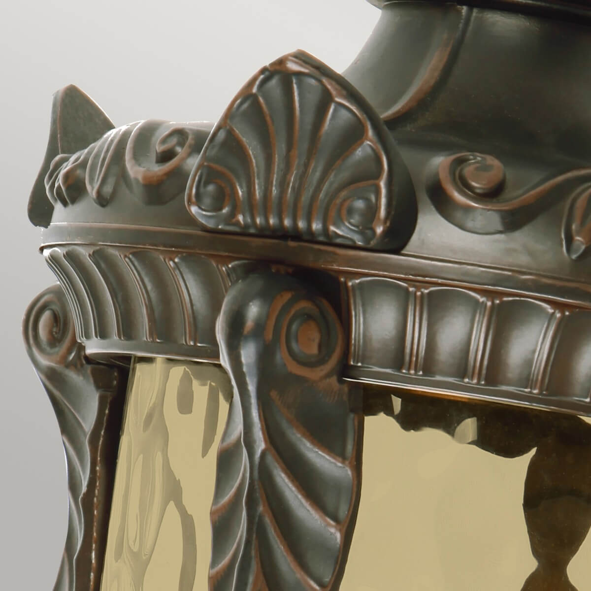 Gros plan des motifs de coquille et du verre ambré de la lanterne.