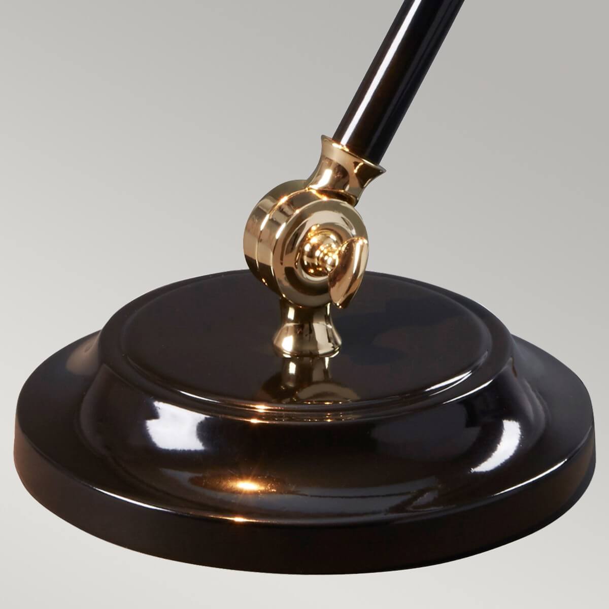 Détail de la base ronde noire et de sa rotule en laiton poli