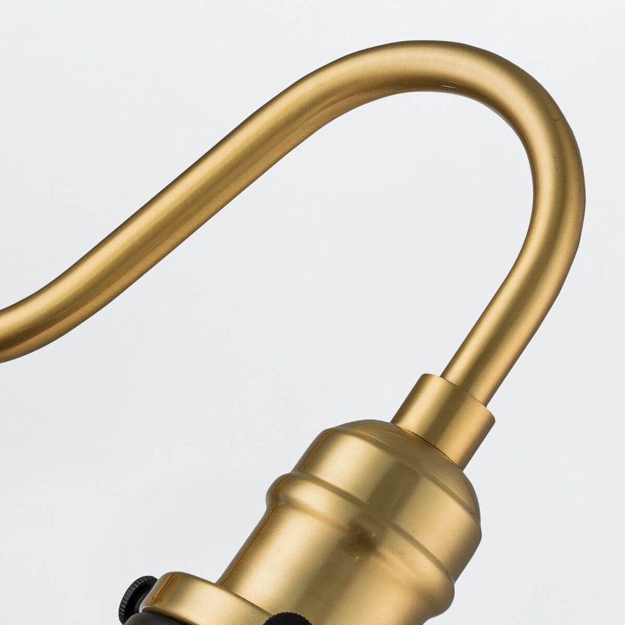 Courbure du bras en laiton reliant la rosace au porte-douille doré