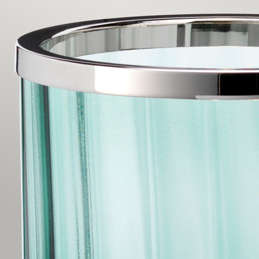 Gros plan sur le cerclage supérieur chromé et le verre vert translucide.