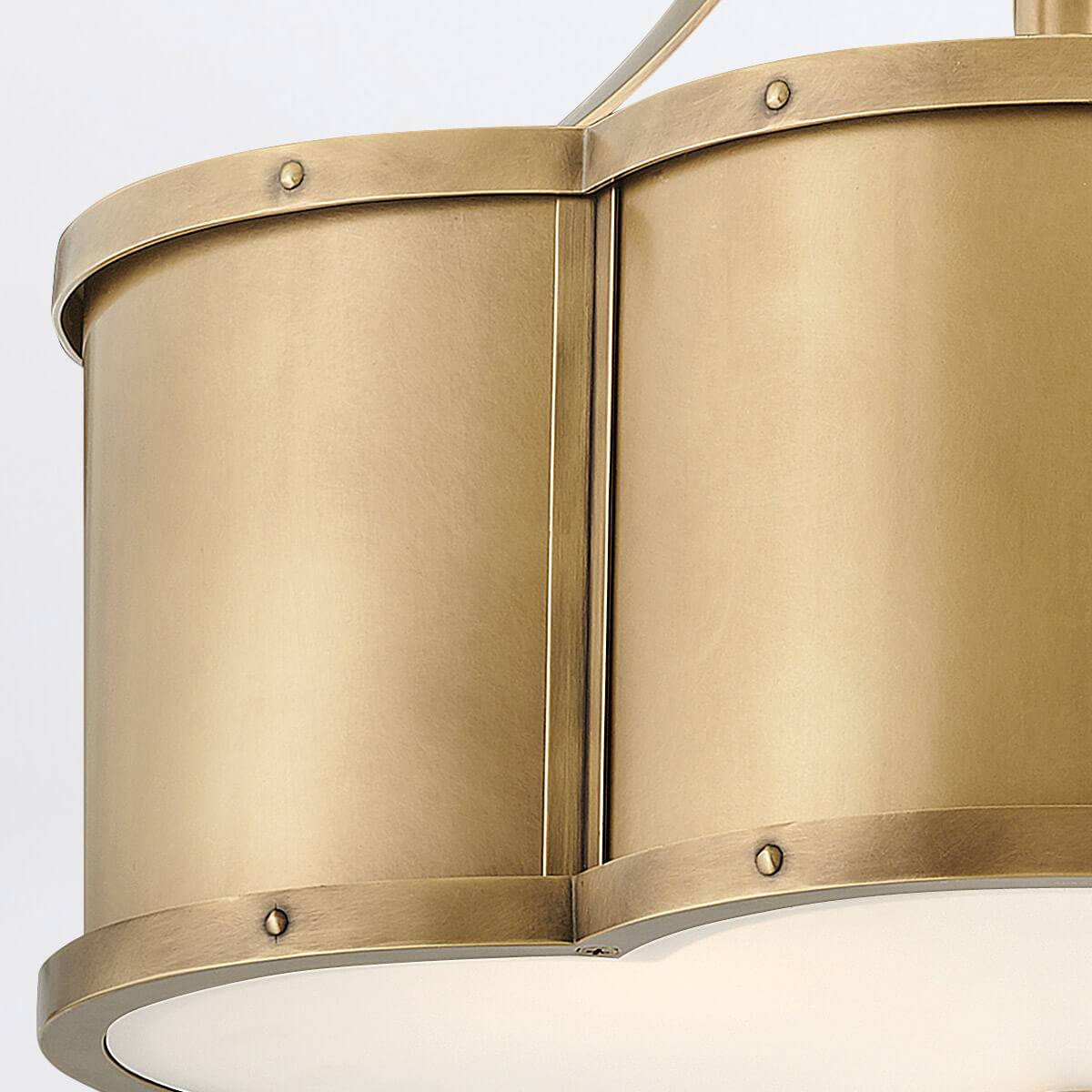 Gros plan sur la jointure verticale des panneaux laiton et leurs rivets apparents