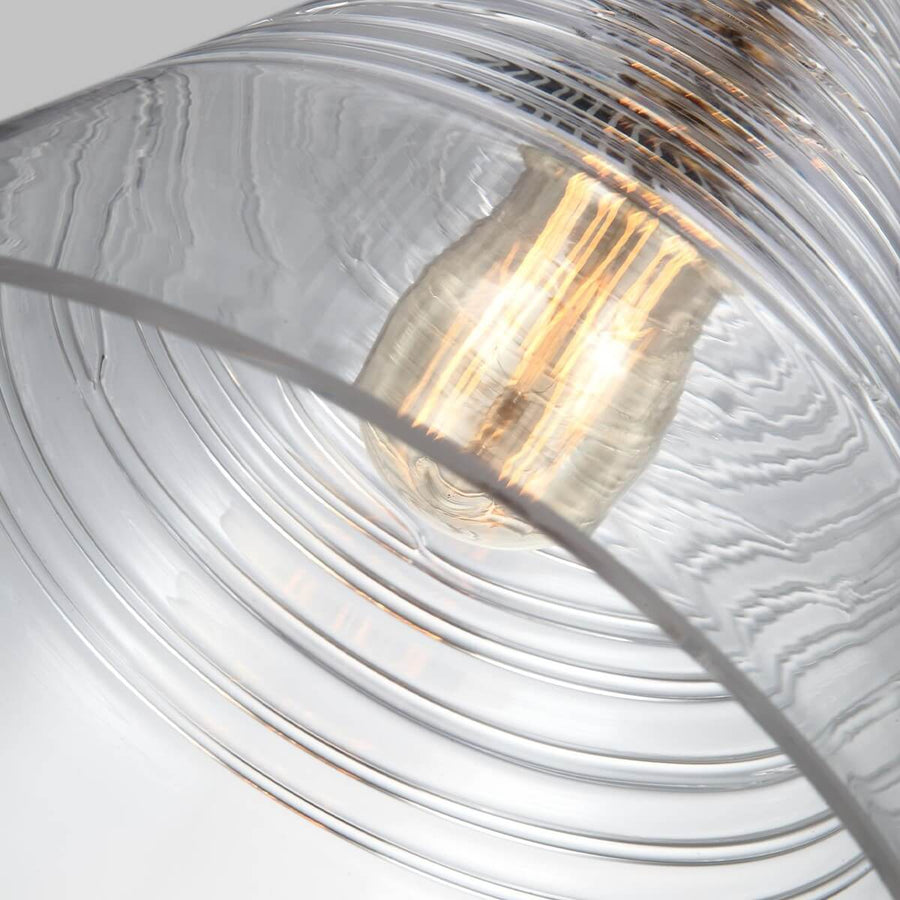 Détail rapproché de l'ampoule allumée derrière le verre strié de rainures horizontales