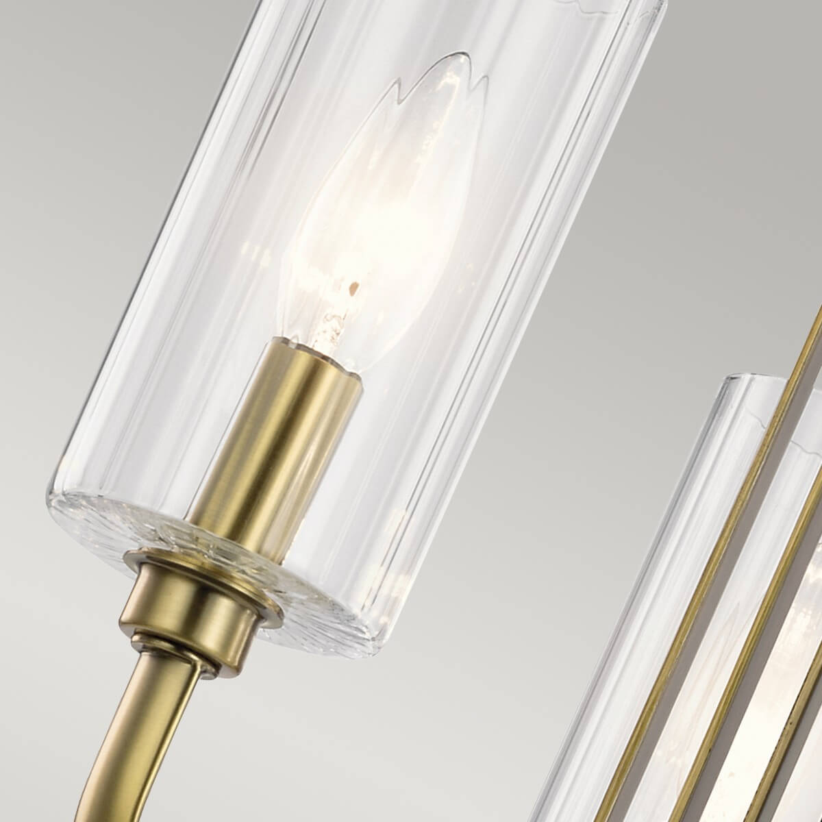 Détail d'une douille en laiton et verre cylindrique avec ampoule allumée à l'intérieur