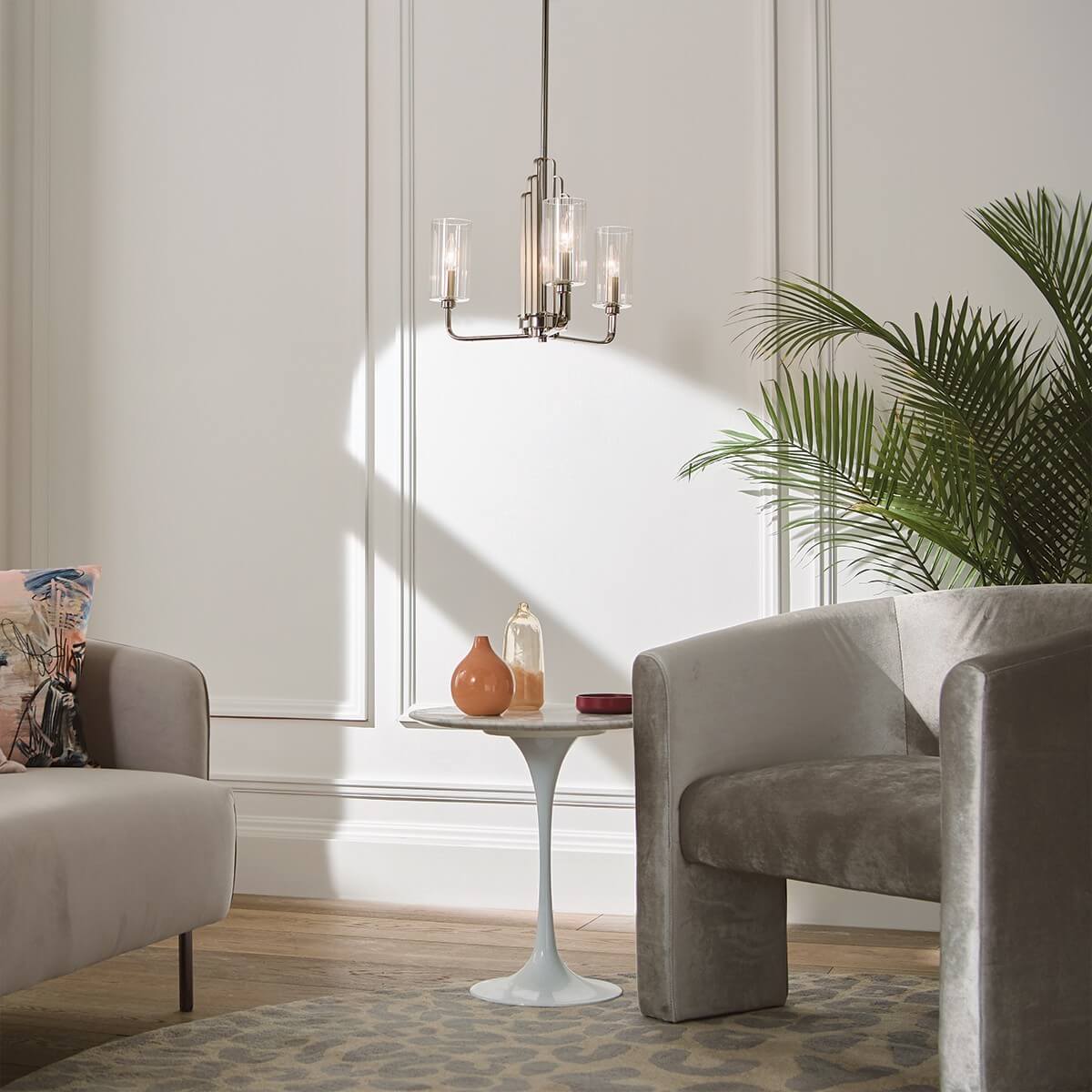 Mise en ambiance du lustre au-dessus d'une table basse, fauteuils et plante