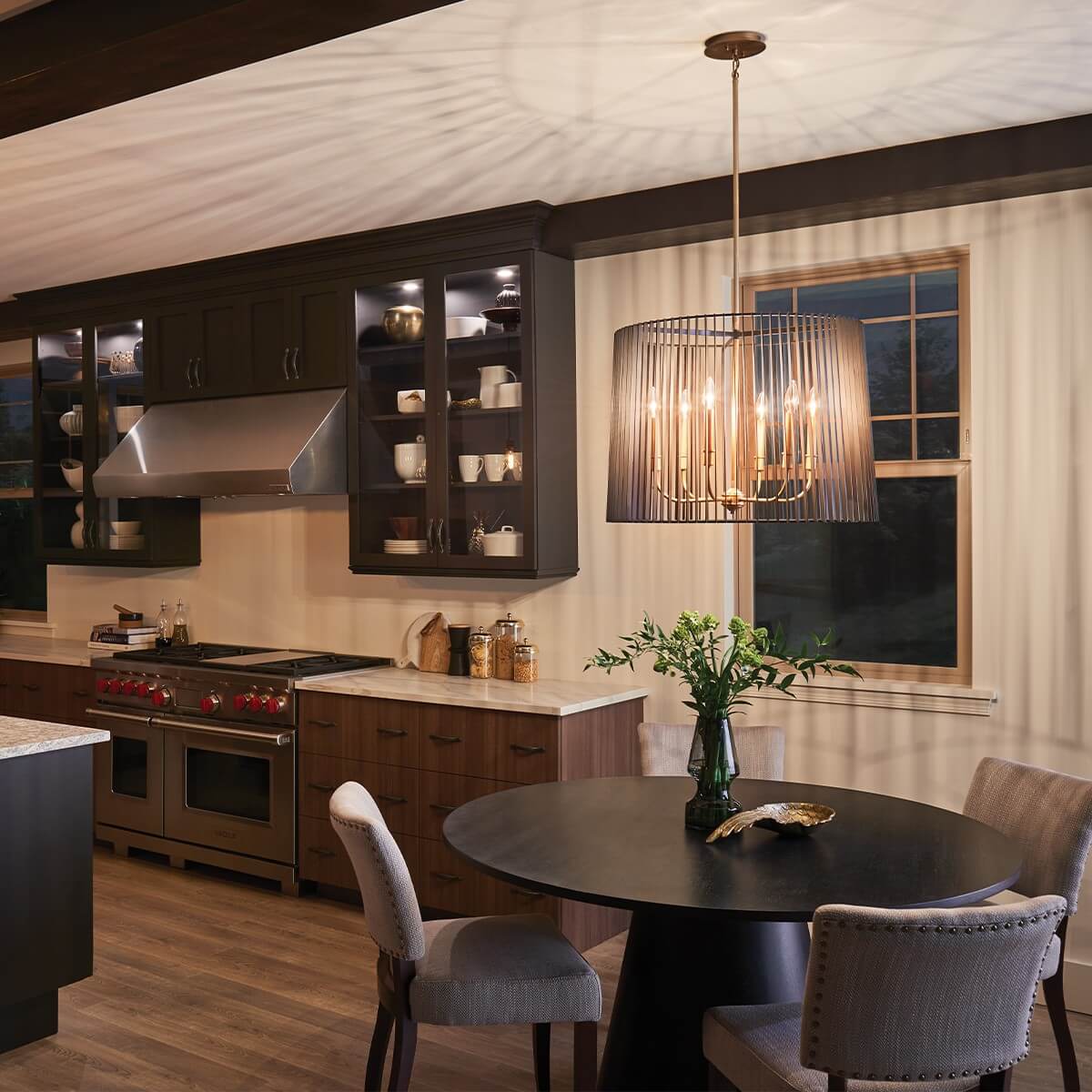 Mise en ambiance du luminaire suspendu au-dessus d'une table ronde dans une cuisine.