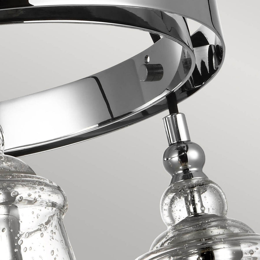 Gros plan sur le cercle métallique chromé et les pendants en verre moucheté