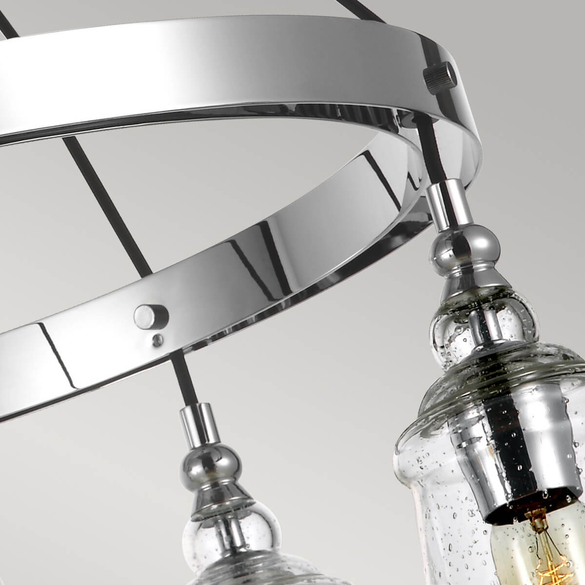Gros plan sur l'anneau chromé et la fixation des suspensions en verre