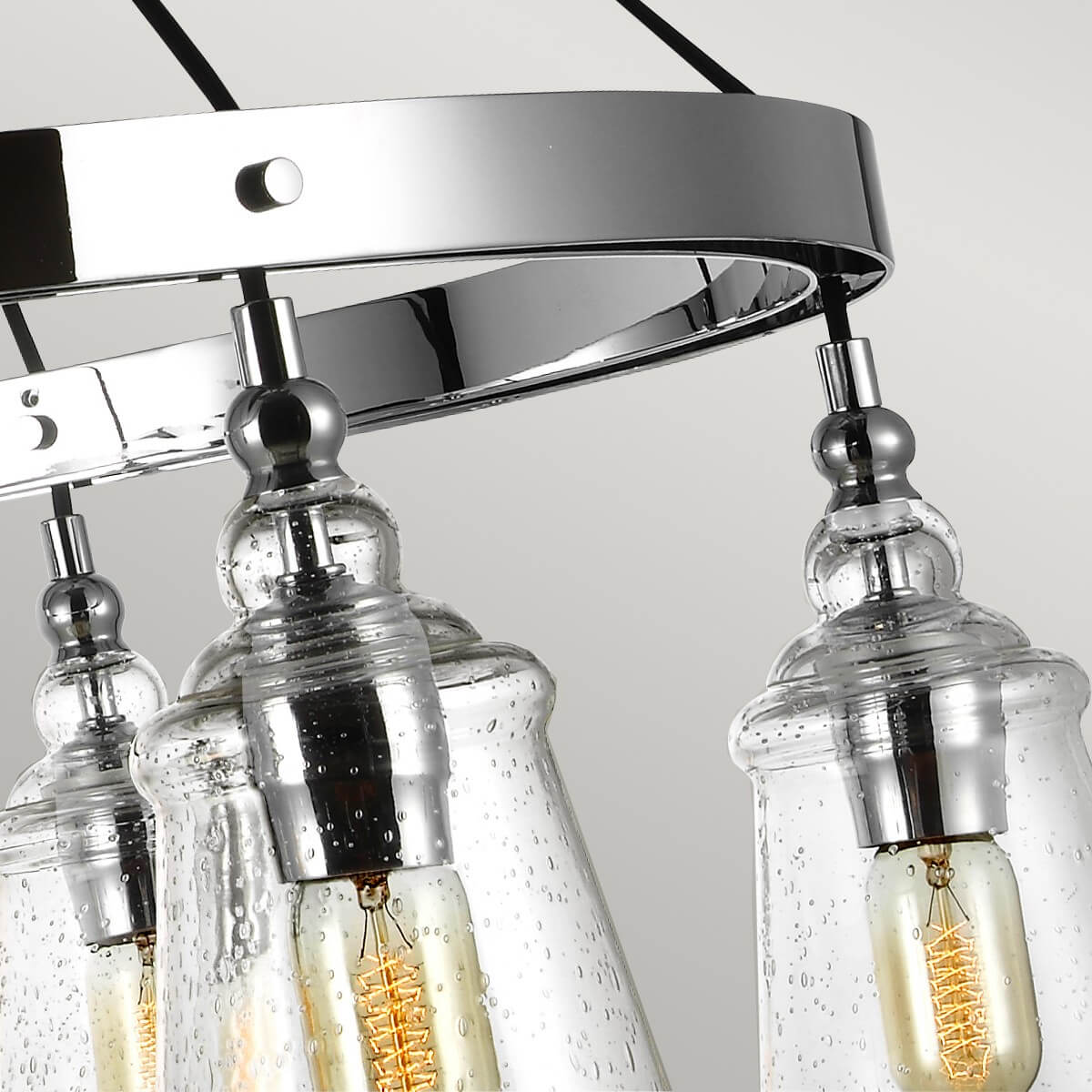 Gros plan de l'anneau chromé et des fixations des suspensions en verre