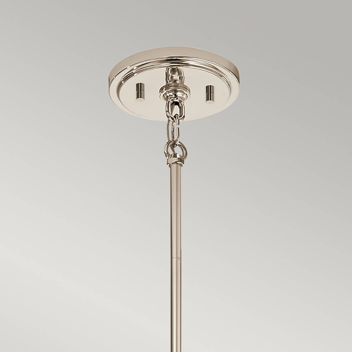 Détail de la rosace ronde en nickel poli fixée au plafond avec chaînette