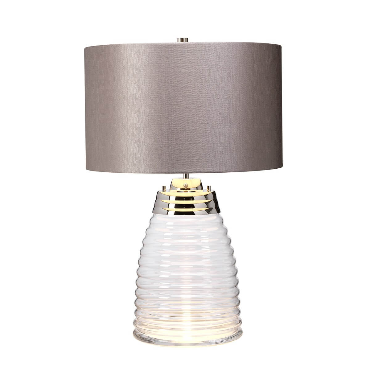 Lampe allumée de face, lumière chaude traversant le socle en verre
