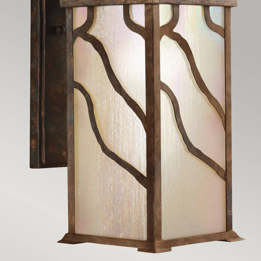 Détail du bas de l'applique avec verre strié et motifs métalliques en vagues.