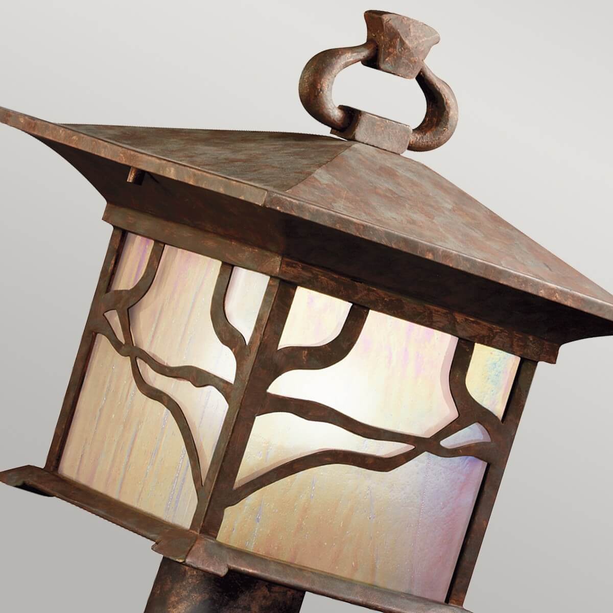 Détail du motif branches d'arbre découpé devant le verre irisé de la lanterne