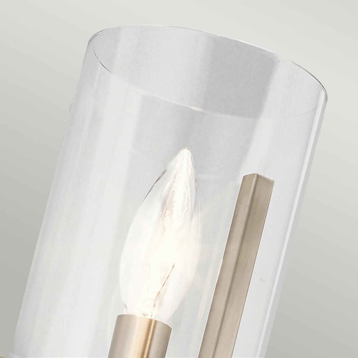 Détail du verre transparent cylindrique et de l'ampoule à filament allumée.