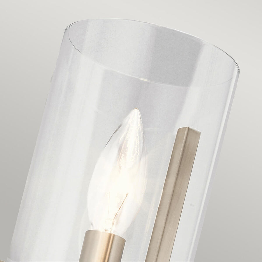 Détail du verre transparent cylindrique et de l'ampoule à filament allumée.