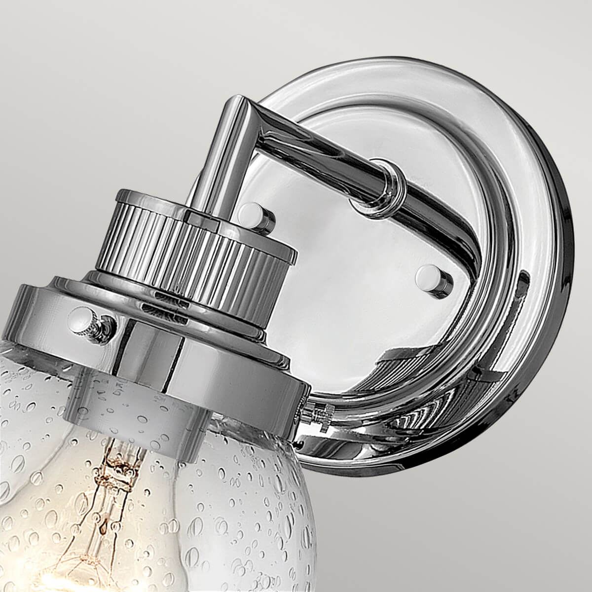 Gros plan du bras coudé brillant et du support circulaire fixé au mur