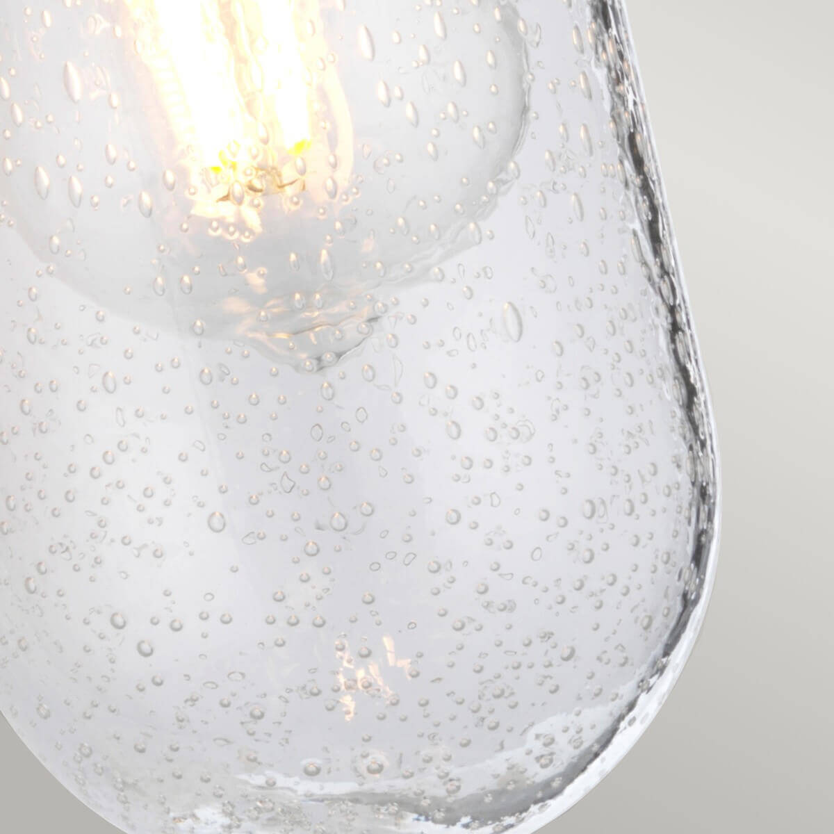 Détail rapproché du verre moucheté transparent laissant voir l'ampoule à filament