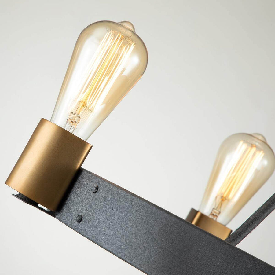 Gros plan sur une douille en laiton et ampoule Edison transparente allumée.
